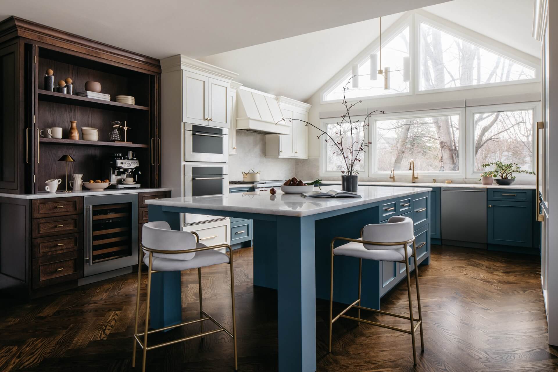 Kitchen remodeling design featuring navy cabinetry, white upper cabinets, a large island, bar seating, and natural light.